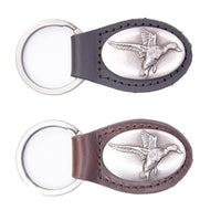 Two leather keychains with silver duck designs on a white background