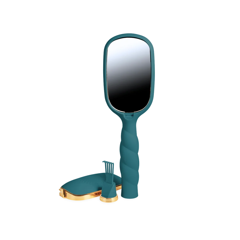 A teal handheld vanity mirror with a twisted handle, shown with a matching teal and gold stand and small accessory piece on a plain white background.