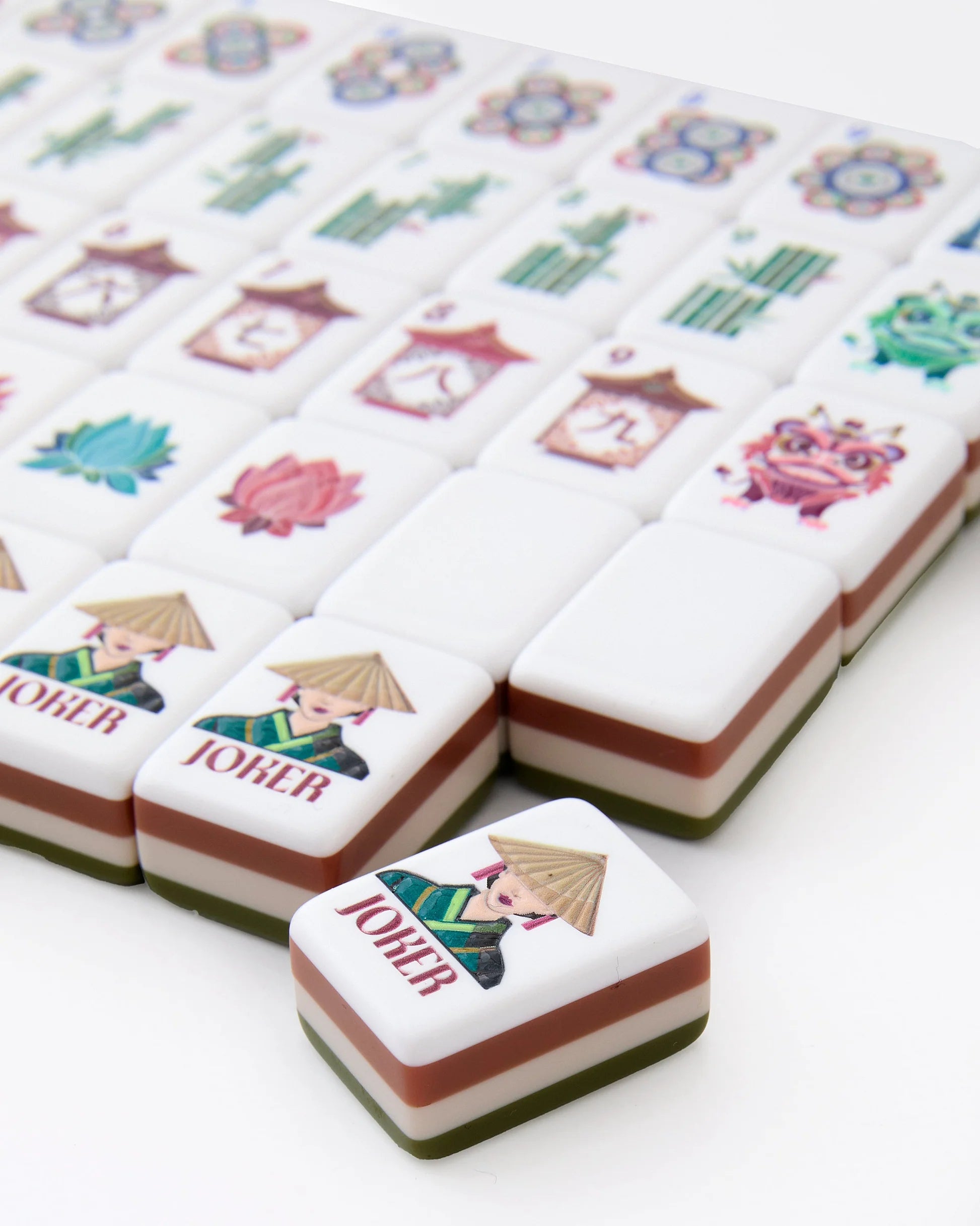 Mahjong tiles with decorative labels featuring characters and symbols on a white background