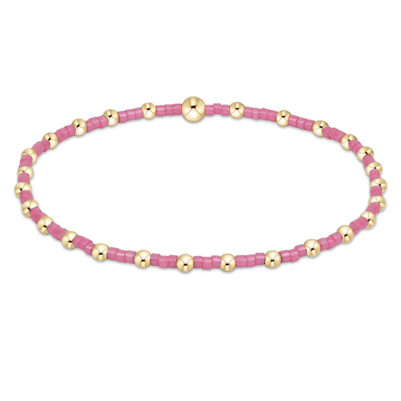 Bracelet with pink and gold beads on a white background