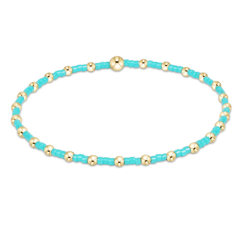 Beaded enewton bracelet with turquoise and gold beads on a white background