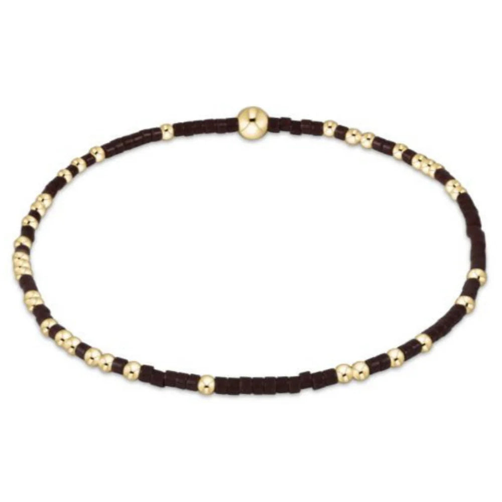 Bracelet with brown seed beads and gold beads on a white background