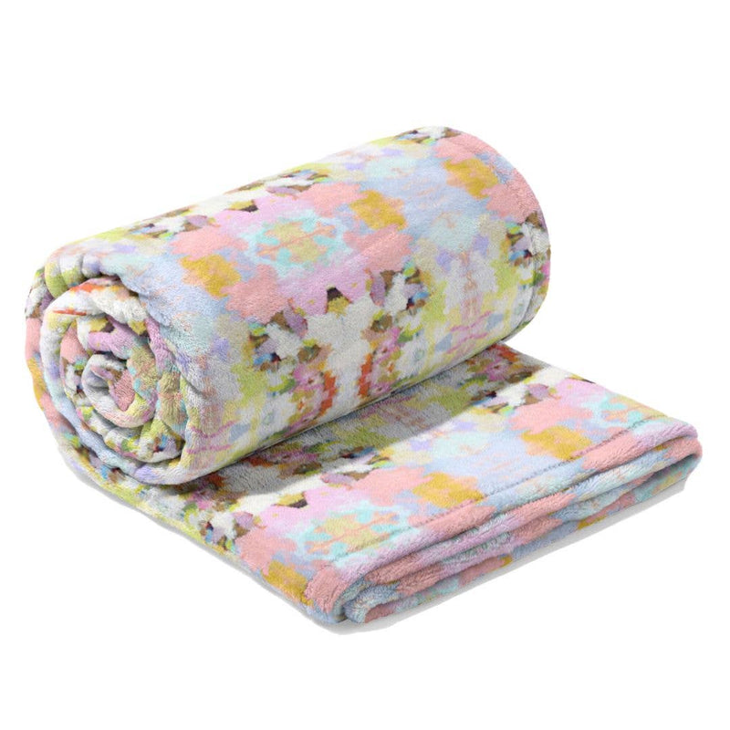 Floral patterned blanket rolled up and unfolded on a white background