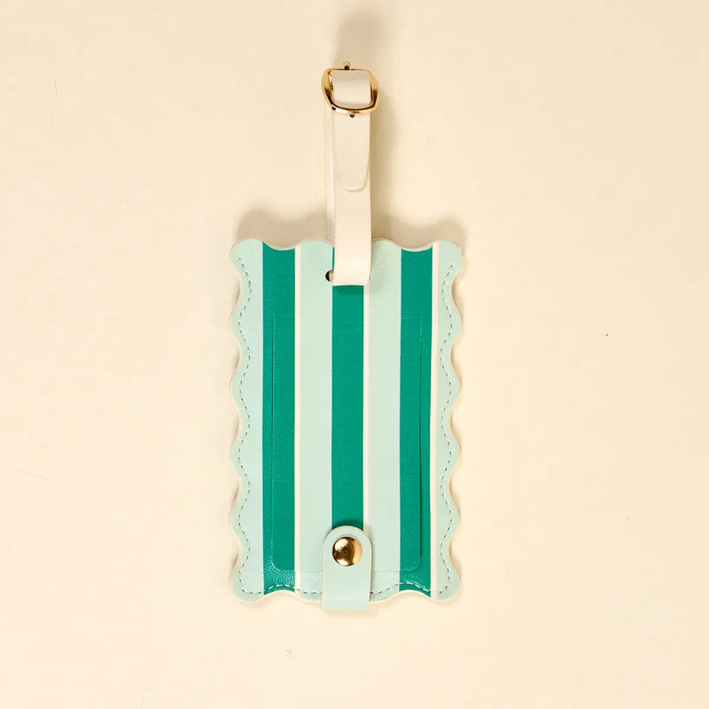 Striped luggage tag with gold accents on a beige background