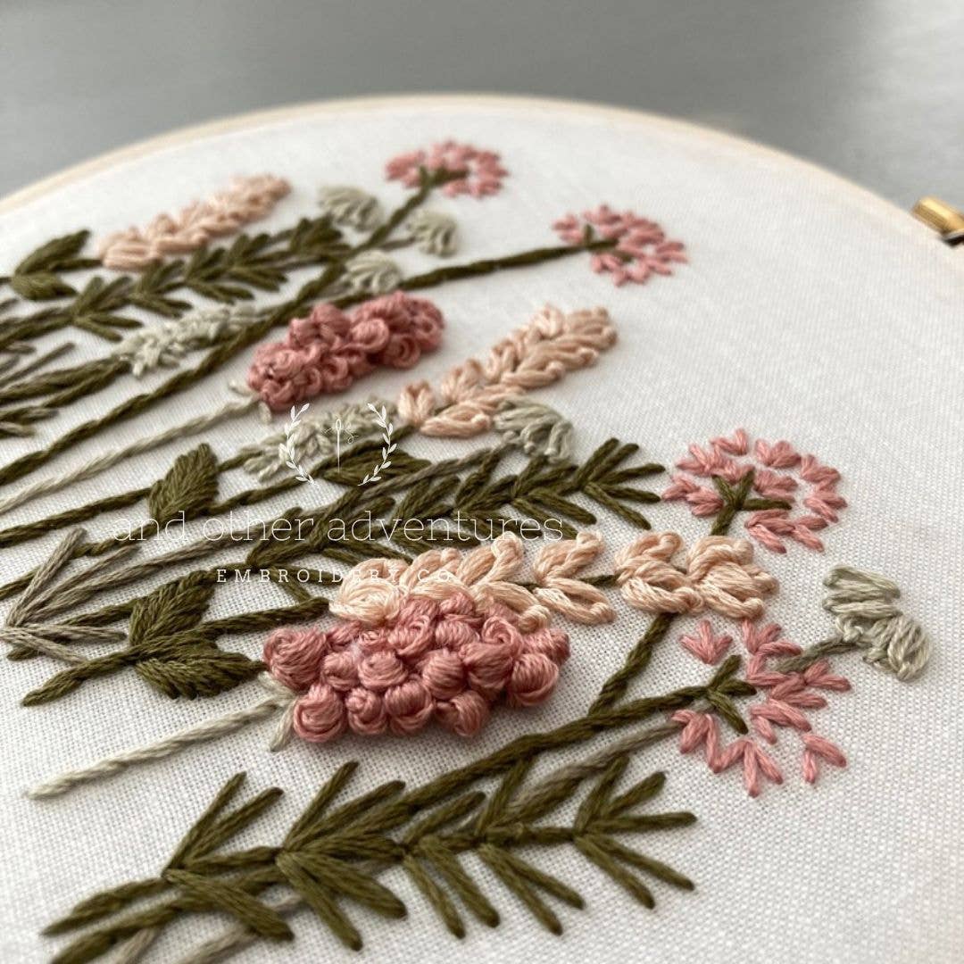 Embroidery hoop with floral embroidery on a white background