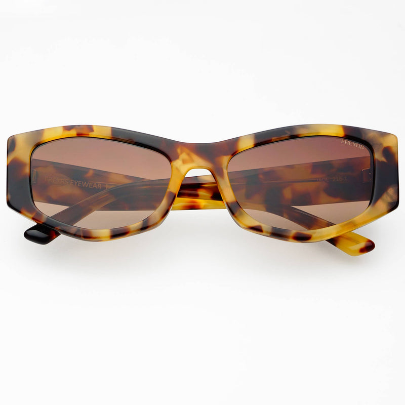 Sunglasses with tortoiseshell frame and brown lenses on a white background