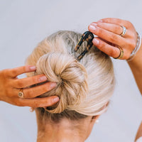 Woman with blonde hair in bun secured by french hair pin