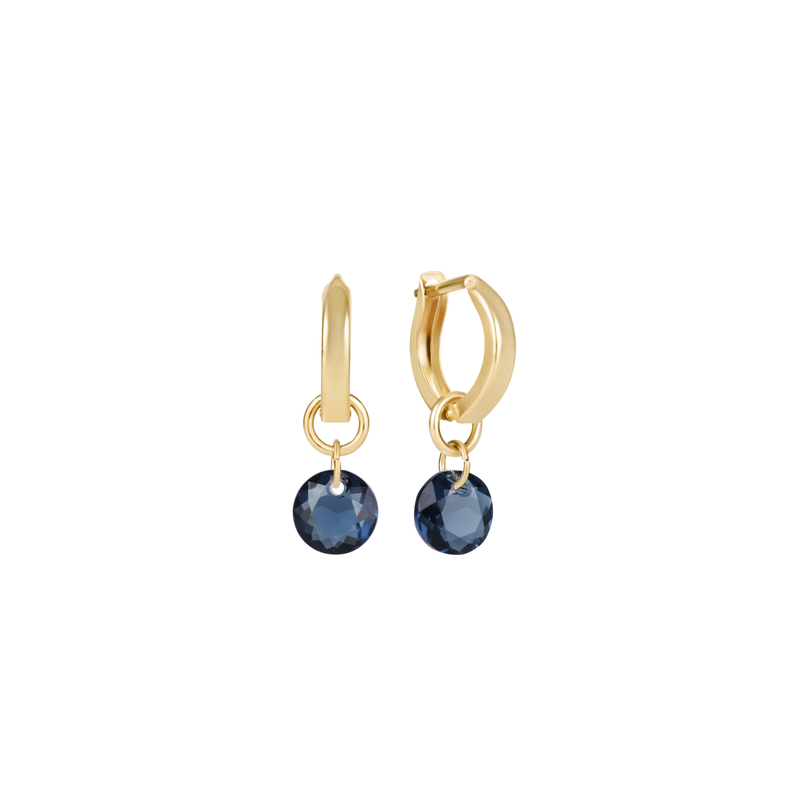 Gold hoop earrings with blue gemstones on a white background