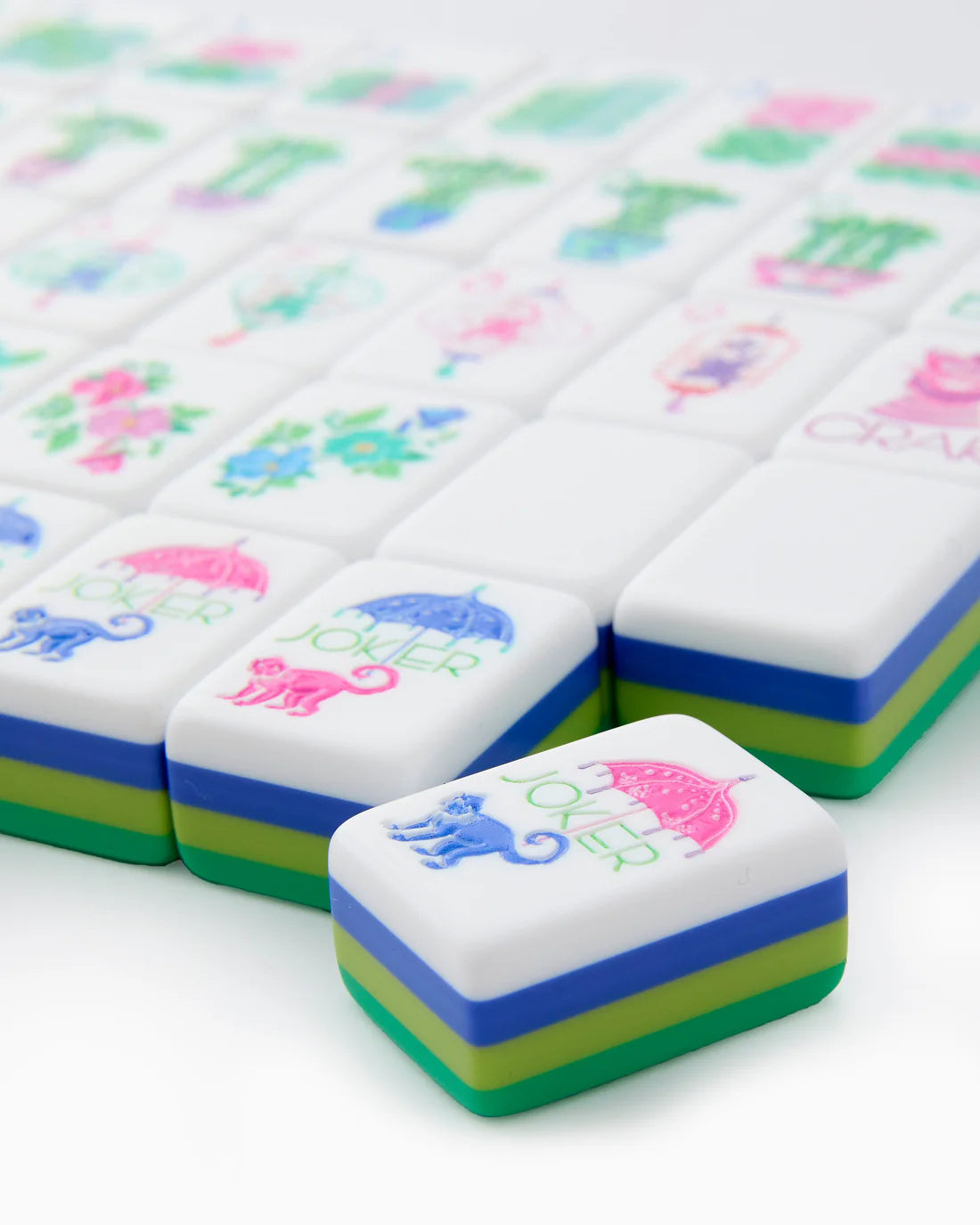 Colorful mahjong tiles with various symbols on a white background