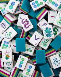Colorful mahjong tiles with various designs and numbers on a white background