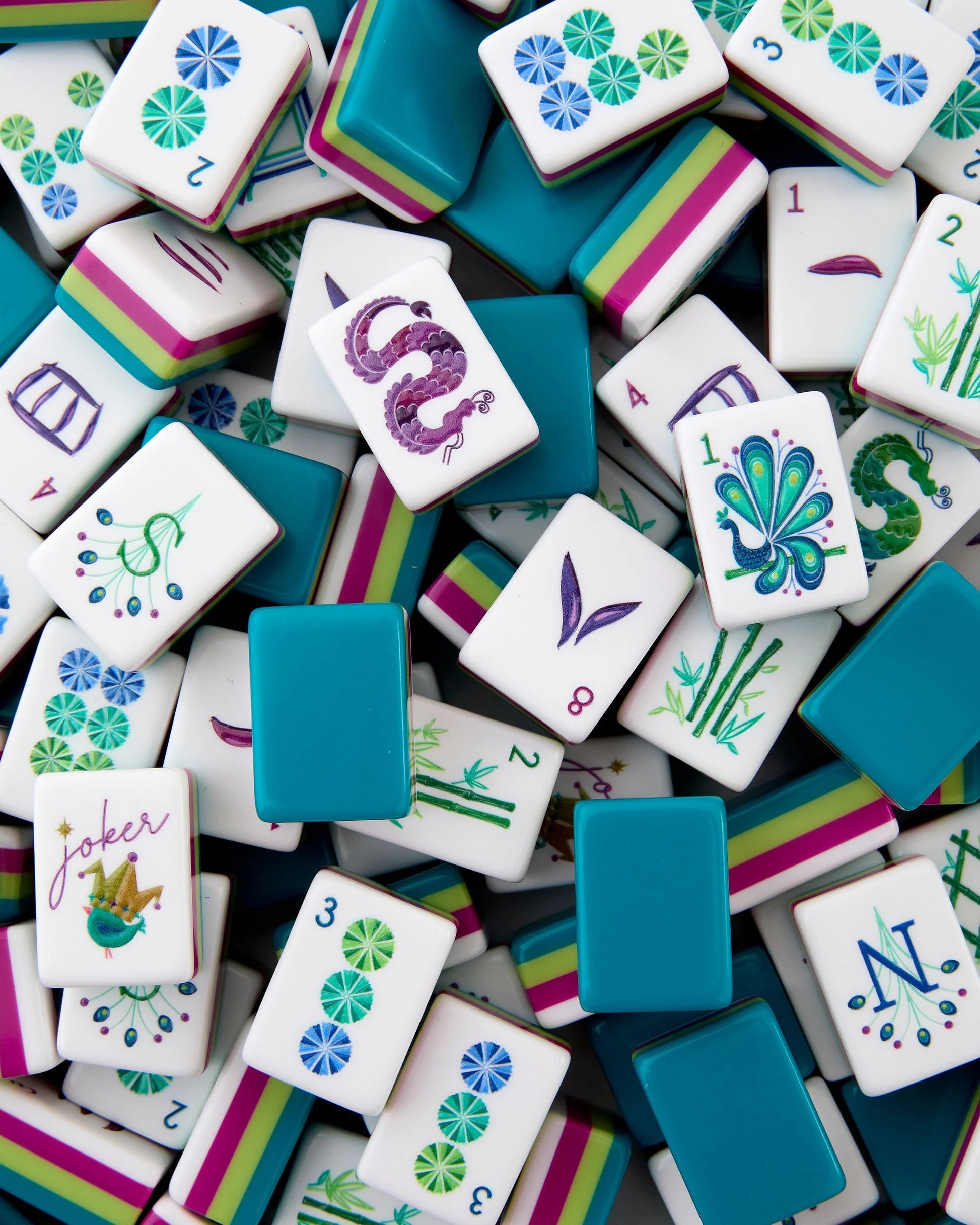 Colorful mahjong tiles with various designs and numbers on a white background