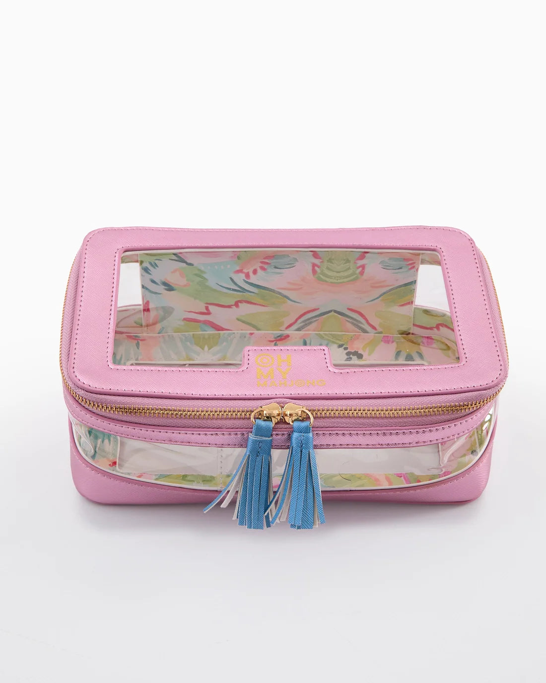A pink travel pouch with a clear window showing a colorful floral pattern inside, featuring gold-tone zippers and blue tassels, on a white background.