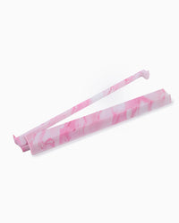 Pink and white marbled mahjong rack and pusher on a white background