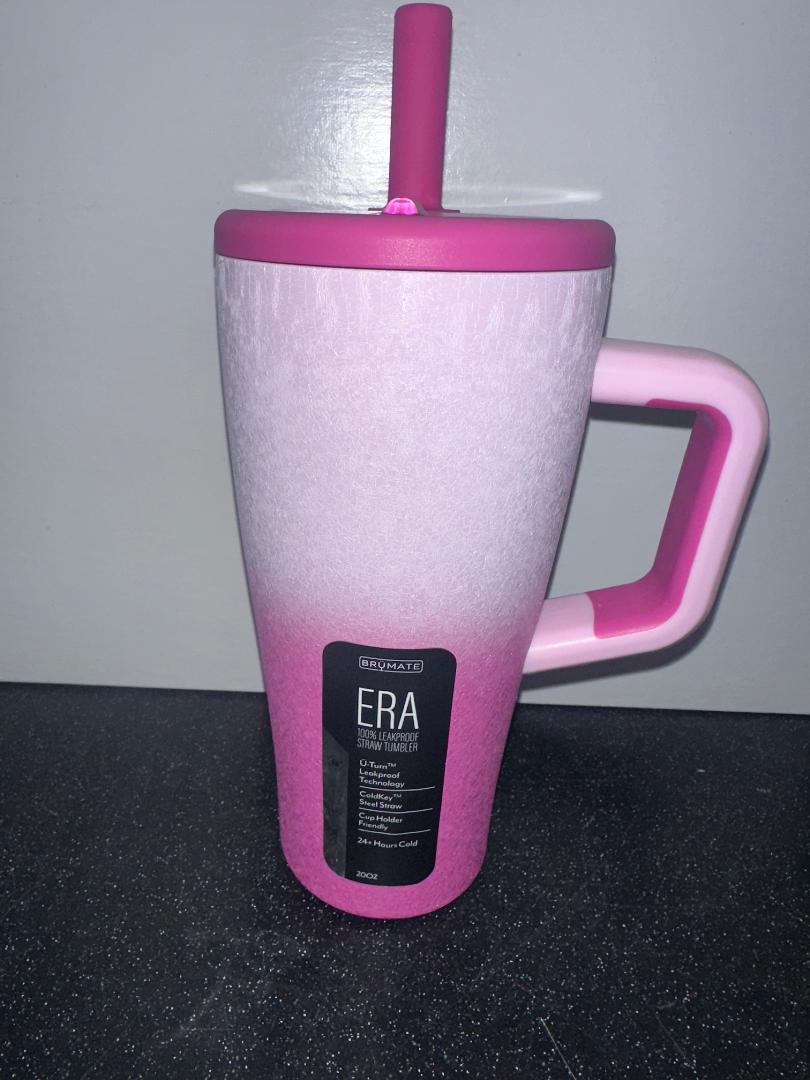 Pink and white tumbler with handle on a dark surface