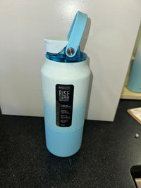Light blue water bottle with a black label on a dark surface.