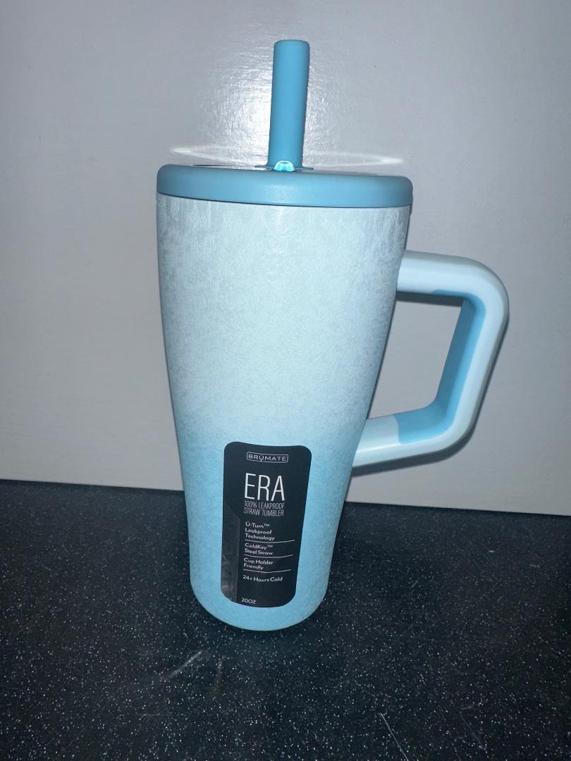 Blue mug with handle and straw on a dark surface