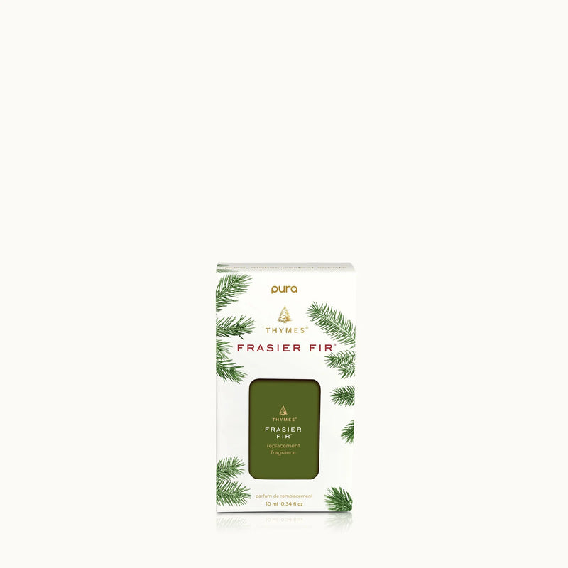A boxed fragrance product labeled 'pura THYMUS Frasier Fir' with green pine-branch illustrations on a white box and a dark olive-green front window showing the product inside, centered on a very light gray background.