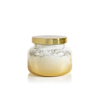 Glass jar with gold lid on a white background