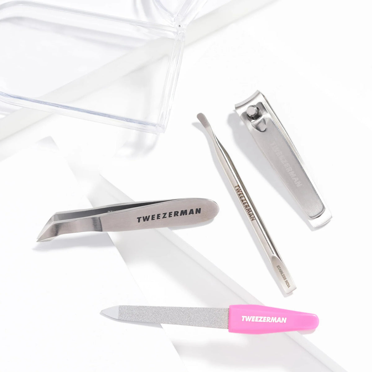 Tweezerman grooming tools including tweezers and a nail clipper on a white background